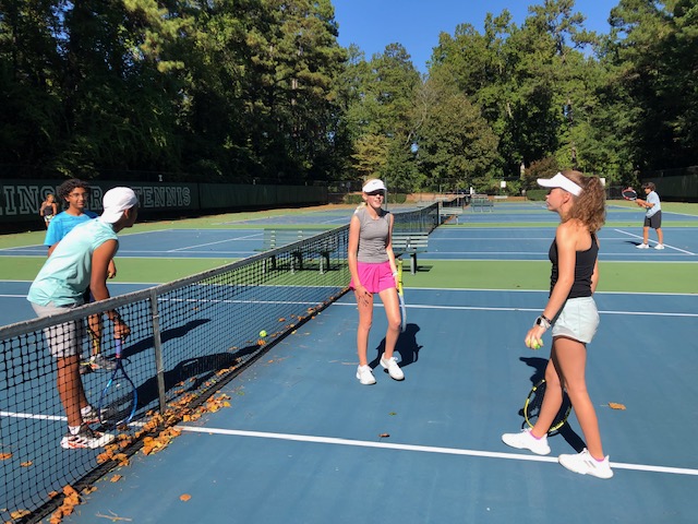 Tennis+players+%28from+the+left%29+Aidan+Merchant%2C+Dev+Katarya%2C+Smith+Easton%2C+and+Caitlin+Pressly+discussing+a+point+with+fall+leaves+present.+Image+Credit%3A+Jennifer+Speir