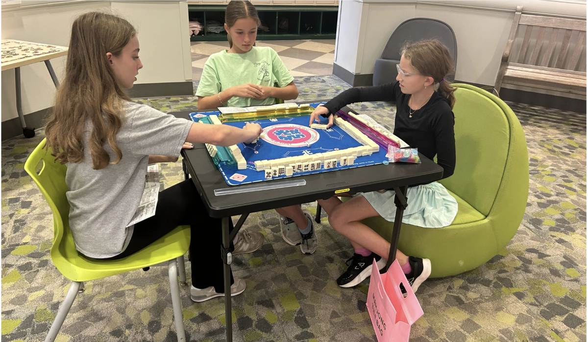 Three members focus on their game at Mahjong Club.