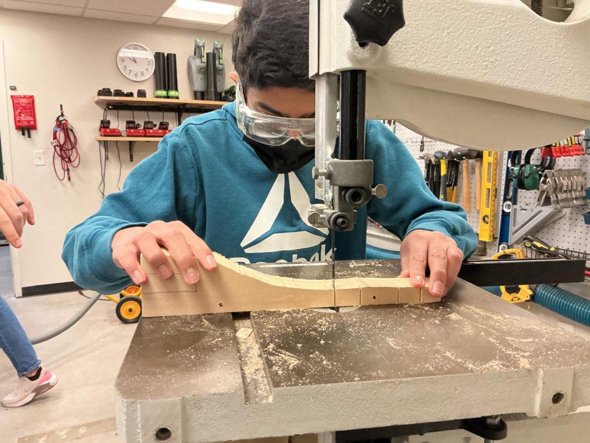 Mihir Gupta uses the band saw to make relief cuts in his dragster, Cosmo.