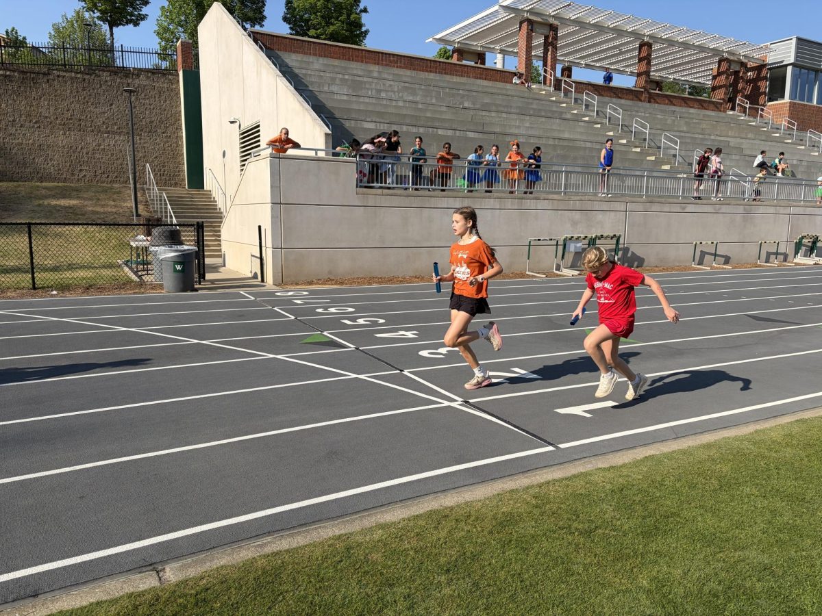 Josie Dennard and Ailsa Groves crossing the finish line after the 4x100 relay.